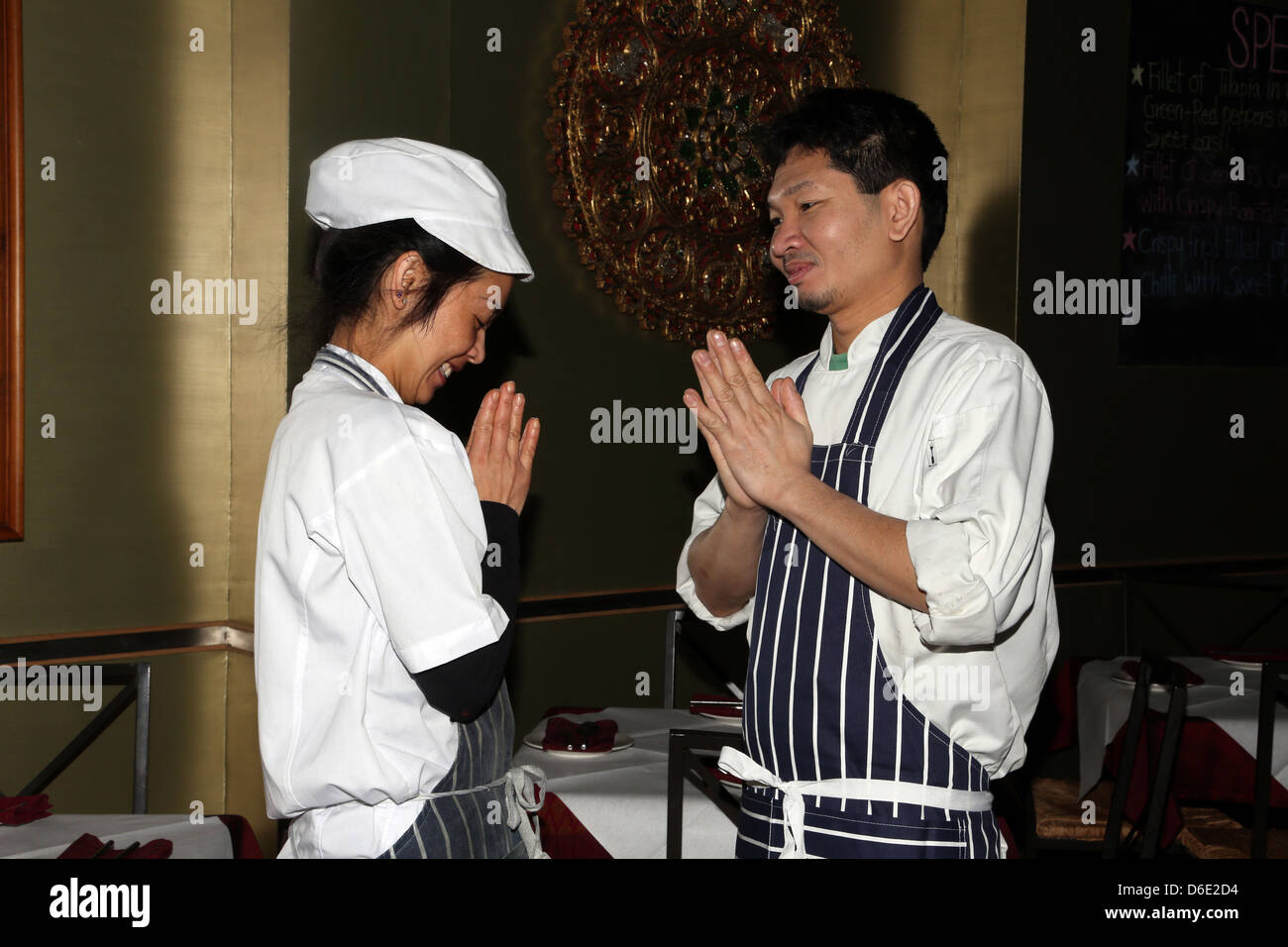 Thai Man And Woman Greeting Each Other In Lotus Position (Wai) Stock Photo