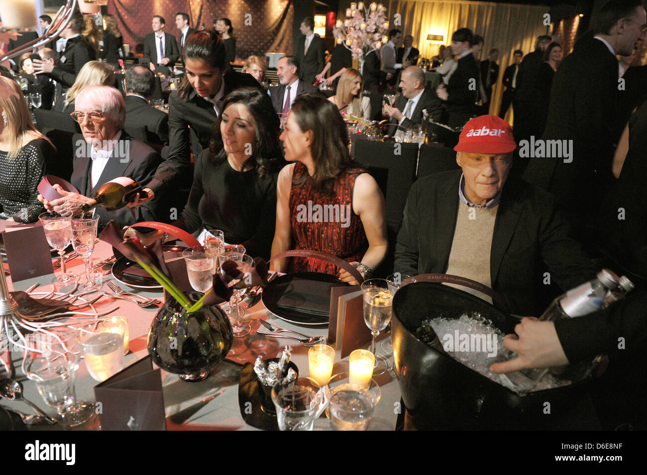 Primary authority of Formula One racing and business magnate Bernie Ecclestone (4-L), his partner Fabiana Flosi, Former Austrian race driver Niki Lauda (R) and his wife Birgit (2-R) sit at the table at the Kitz Race Party, an event that traditionally takes place after the legendary Hahnenkamm downhill alpine ski race, in Kitzbuehel, Austria, 21 January 2012. The party is a meeting  Stock Photo