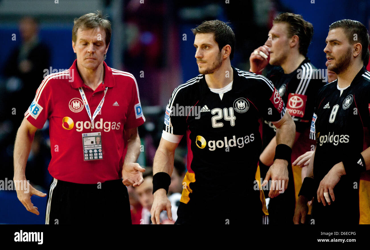 Germany's head coach Martin Heuberger (L-R) and players Michael Haass, Lars Kaufmann and Christoph Theuerkauf stand on the sidelines during the group 1 match between Poland and Germany at the European Handball Championships in Belgrade, Serbia, 25 January 2012. Photo: JENS WOLF Stock Photo