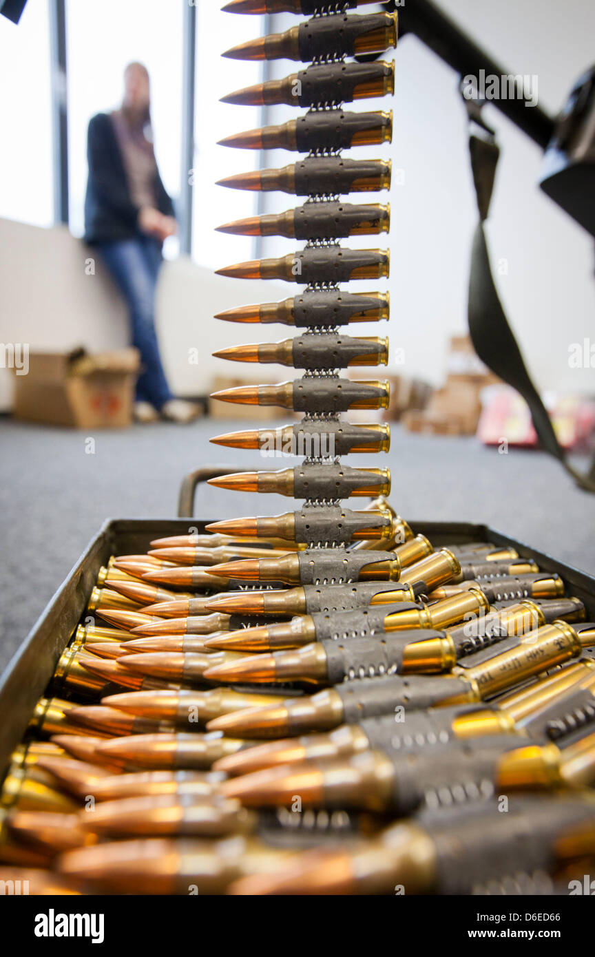 A journalist stands behind ammunition for a MG-3 machine-gun made in Germany at a press conference of the customs investigators office Frankfurt Main, Germany, on 25 January 2012. Investigators raided an apartment of a 46-year-old sports shooter, that was used as arms depot in Viernheim. The officers confiscated two machine-guns, nine assault rifles, two automatic pistols, nine han Stock Photo