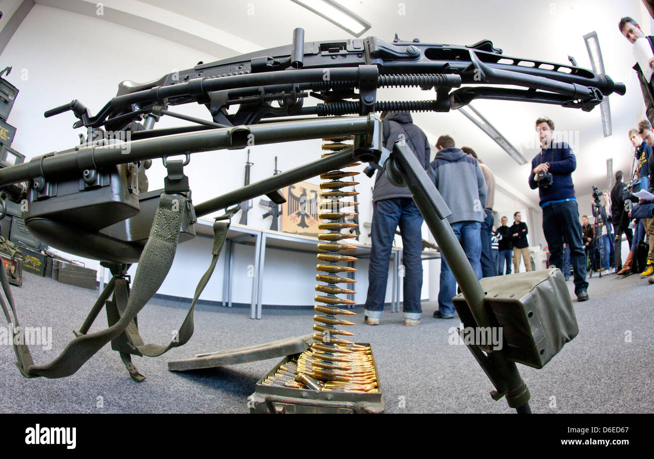 Journalist stand behind a MG-3 machine-gun made in Germany at a press conference of the customs investigators office Frankfurt Main, Germany, on 25 January 2012. Investigators raided an apartment of a 46-year-old sports shooter, that was used as arms depot in Viernheim. The officers confiscated two machine-guns, nine assault rifles, two automatic pistols, nine handguns and more tha Stock Photo