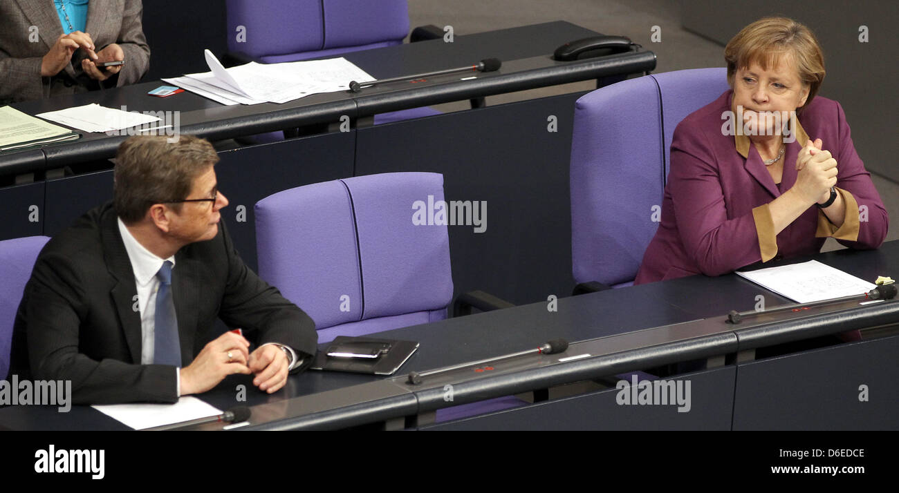 German Chancellor Angela Merkel (CDU) and German Foreign Minister Guido Westerwelle (FDP) follow the debate on the Afghanistan mission (ISAF) at the Bundestag in Berlin, Germany, 26 January 2012. Photo: WOLFGANG KUMM Stock Photo