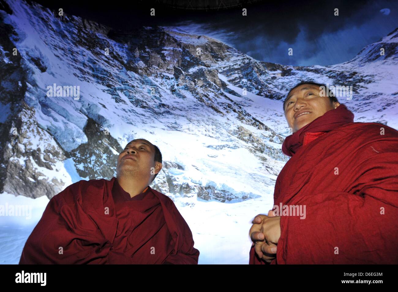 Buddhist monks view a panorama of Mount Everest that is on display at Panometer Leipzig, Germany, 27 January 2012. The panoram is on display until 03 June 2012. Photo: Peter Endig Stock Photo