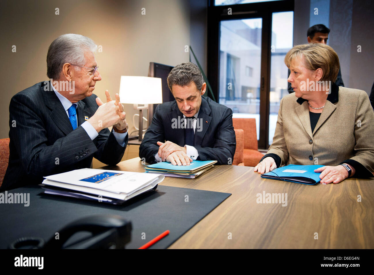 German Chancellor Angela Merkel confers with Italian Prime Minister Mario Monti (L) and French President Nicolas Sarkozy shortly before the EU summit on the debt crisis begins in Brussels, Belgium, 30 January 2012.  Photo: BPA/JESCO DENZEL Stock Photo