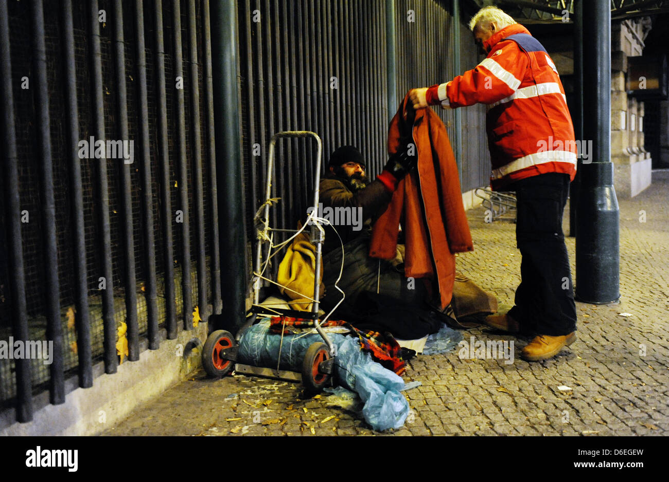 A staff member of the German Red Cross cold assistance takes care of a homeless sleeping on the street in Berlin, Germany, 30 January 2012. Berlin's emergency shelters are fully booked out. The demand of sleeping places is even greater than the current supply. Photo: Maurizio Gambarini Stock Photo