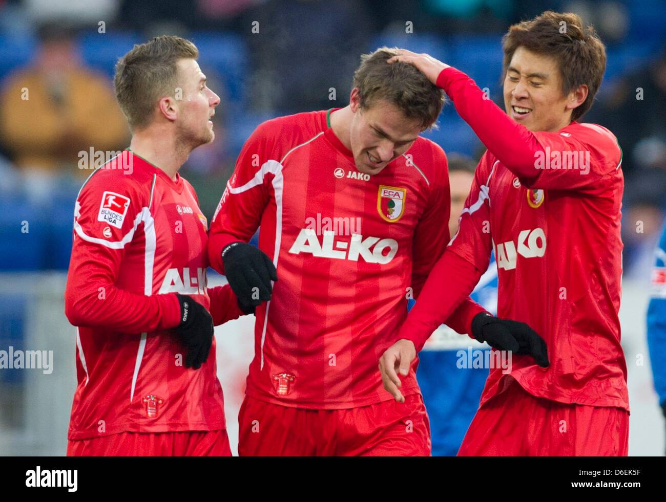Augsburg's Sebastian Langkamp (M) celebrates his 2-2 goal with teammates Daniel Baier (L) and Ja-Cheol Koo during the German Bundesliga match between TSG 1899 Hoffenheim and FC Augsburg at the Rhein-Neckar-Arena in Sinsheim, Germany, 04 February 2012. Photo: UWE ANSPACH    (ATTENTION: EMBARGO CONDITIONS! The DFL permits the further  utilisation of the pictures in IPTV, mobile servi Stock Photo