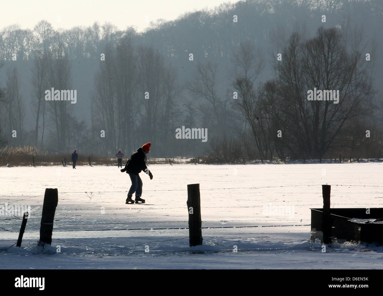 Schlittschuhfahrer gleiten am Montag (06.02.2012) auf dem zugefrorenen Altrhein bei Xanten über das Eis. Die starken Minustemperaturen in den letzten Tagen haben die Wasserlandschaft in eine Eisfläche verwandelt.  Foto: Roland Weihrauch dpa/lnw  zu KORR:' Stock Photo