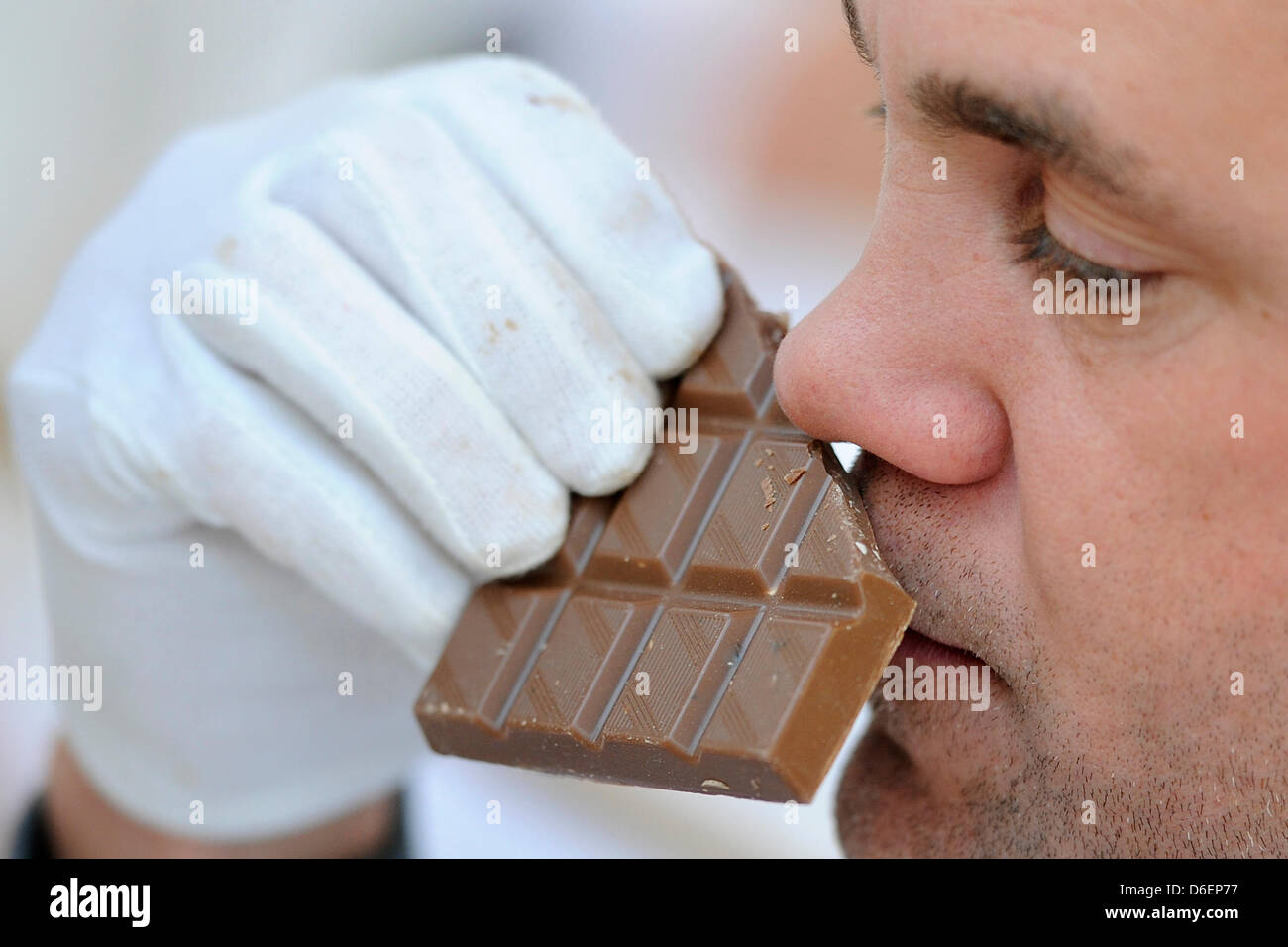 Expert Marc-Andre Loske smells a bar of chocolate at the Central College of the German Confectionery Industry (ZDS) in Solingen, Germany, 08 February 2012. The Food Test Center of the DLG (German Agricultural Association) tests more than 1000 differents candies for four days. The experts assess looks, flavor, texture, rheologic qualities and the melting process amongst others. Phot Stock Photo