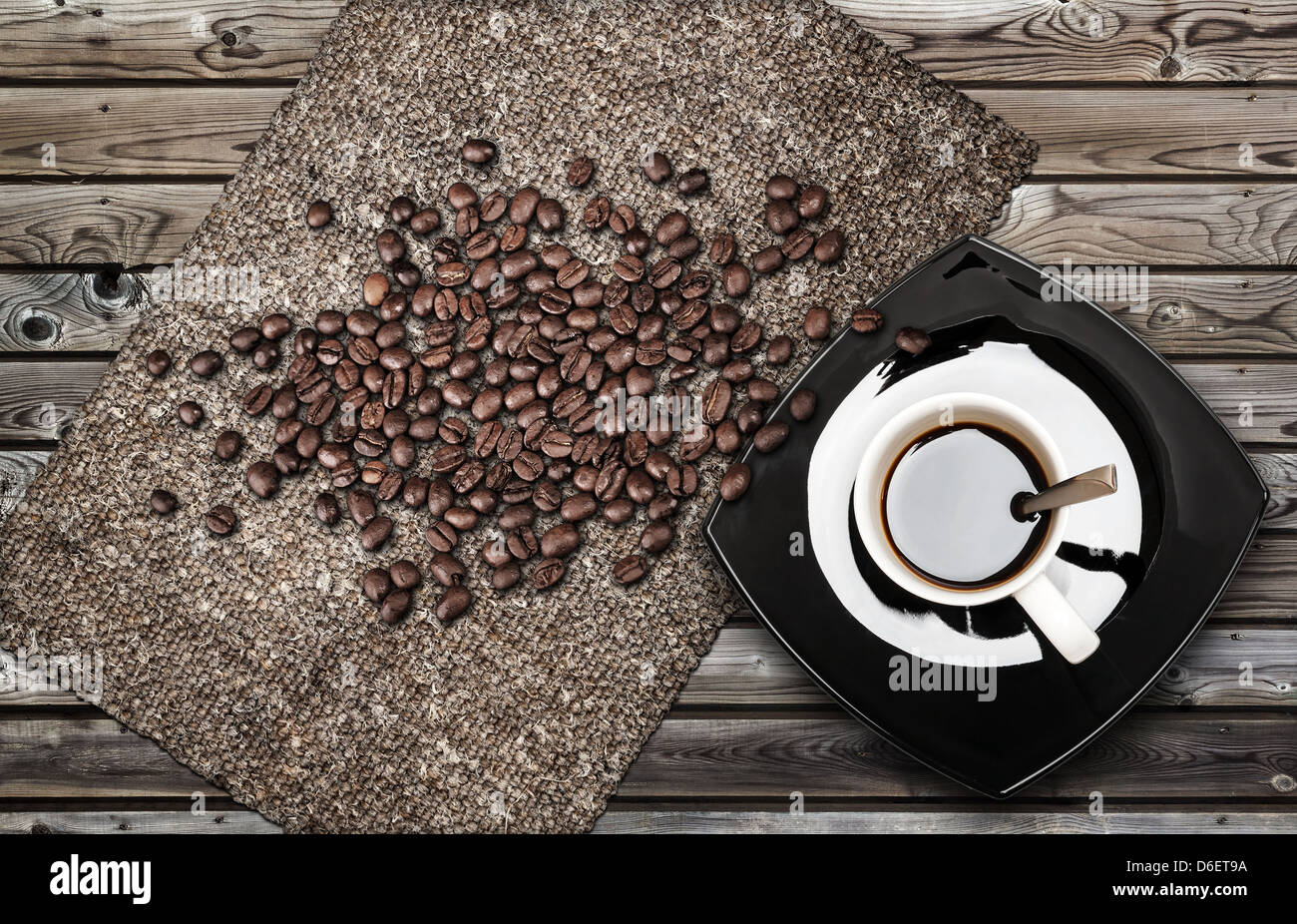 Cup of espresso coffee with beans and canvas on weathered wooden table Stock Photo