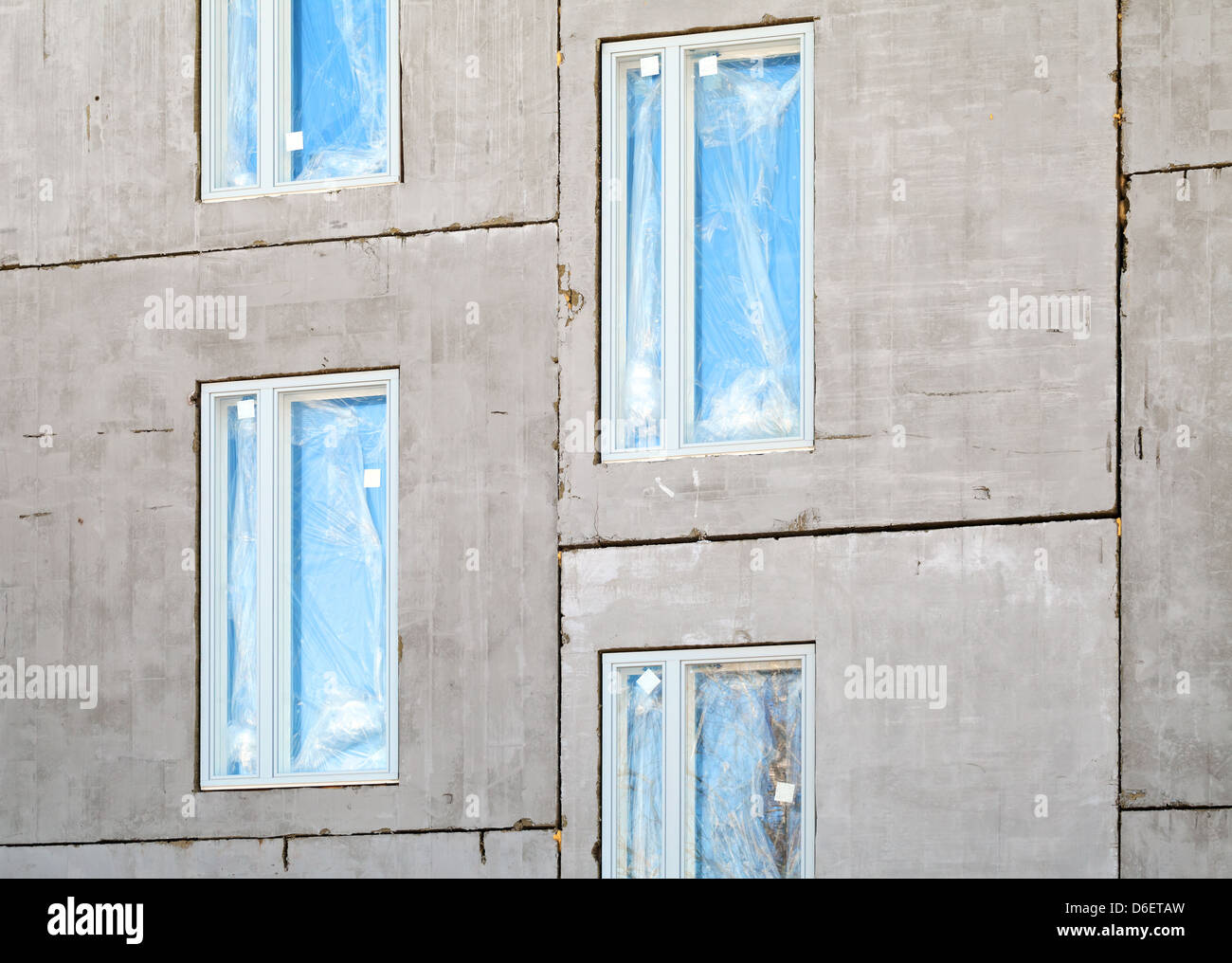 Unfinished building concrete wall with windows. Under construction Stock Photo