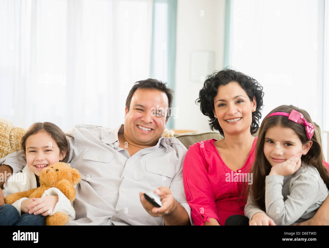 Family watching television together on sofa Stock Photo