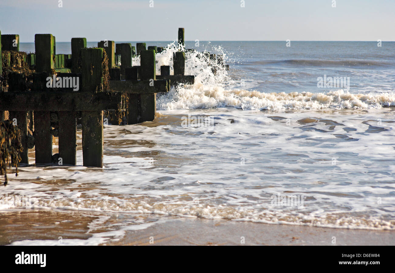 A view of a wooden breakwater and wave action at Bacton-on-Sea, Norfolk, England, United Kingdom. Stock Photo