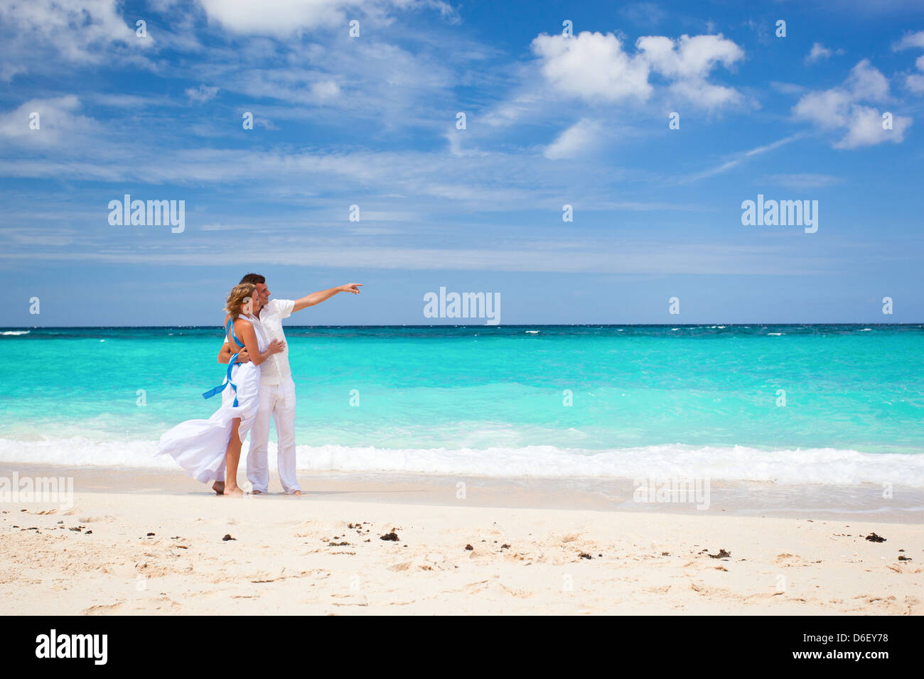 Bride and groom on tropical beach, walking Stock Photo