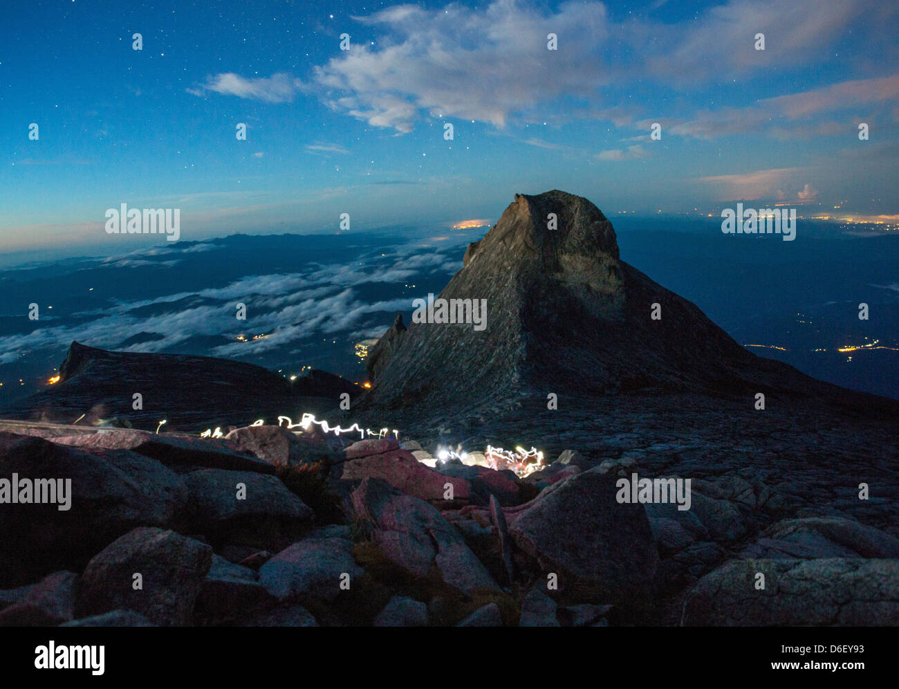 Before dawn on the summit of Gunung Kinabalu Borneo with climber's head torches starry sky and St John's Peak beyond Stock Photo