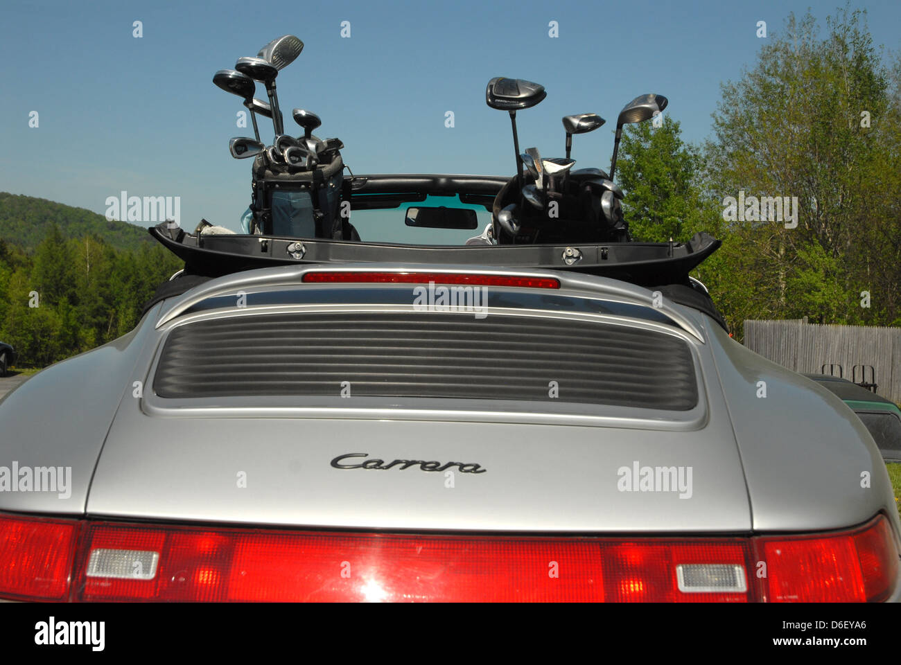 A pair of golf bags sit in the back seat of a Porsche Carrera awaiting use  Stock Photo - Alamy