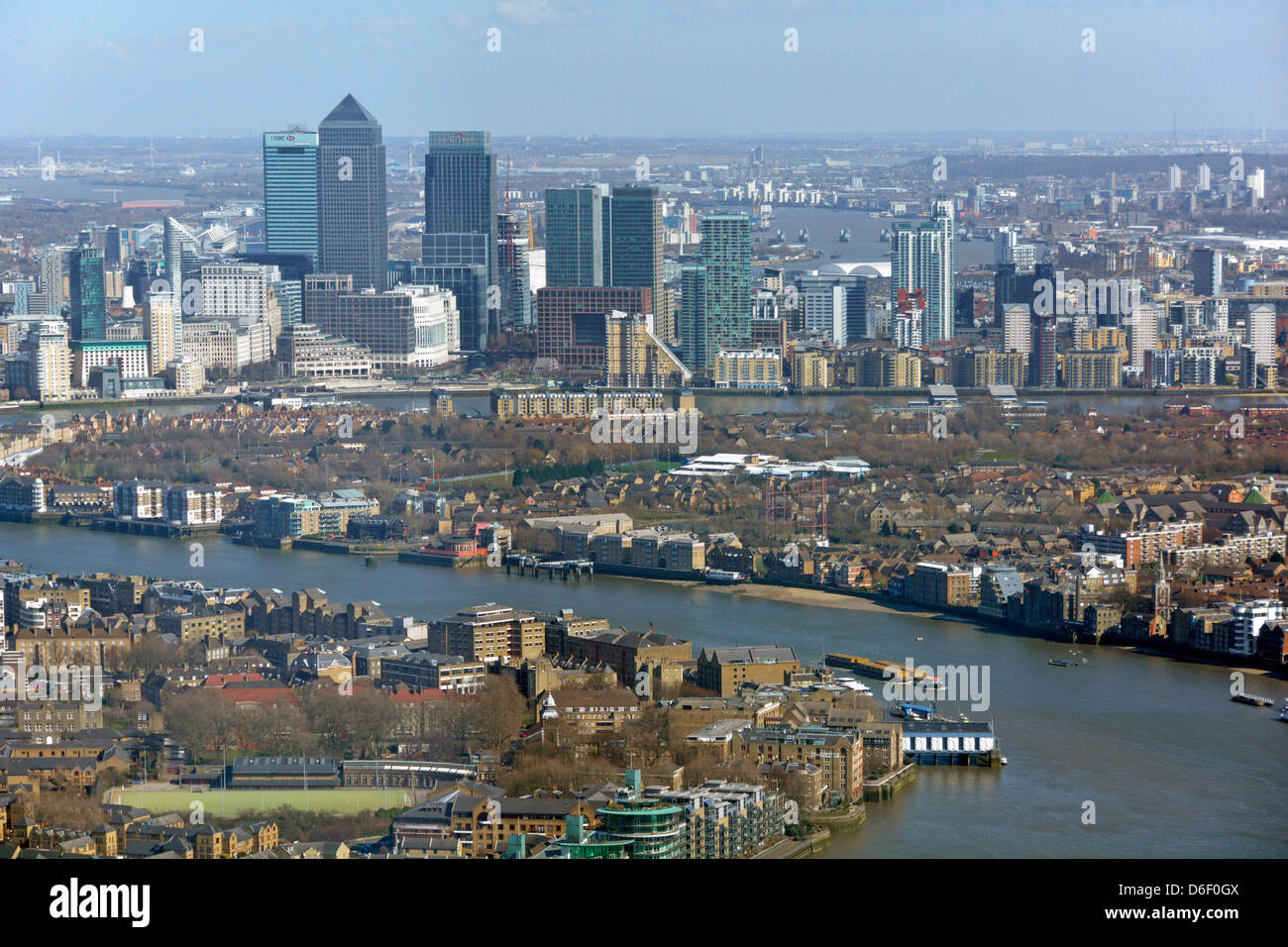 Aerial view London urban landscape & cityscape landmarks at Canary Wharf skyline bends in River Thames flood barrier piers distant England UK Stock Photo