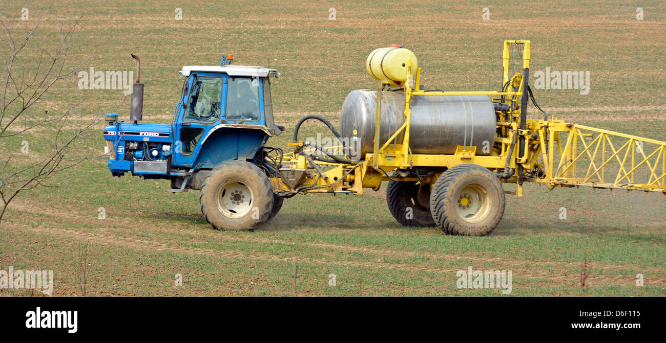 Farmer driving tractor towing specialised agriculture crop spraying