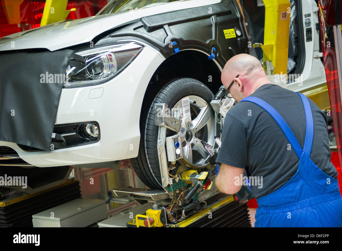 An employee of car manufacturer BMW work on a car at the BMW factory in Regensburg, Germany, 10 April 2013. Photo: Marc Mueller Stock Photo
