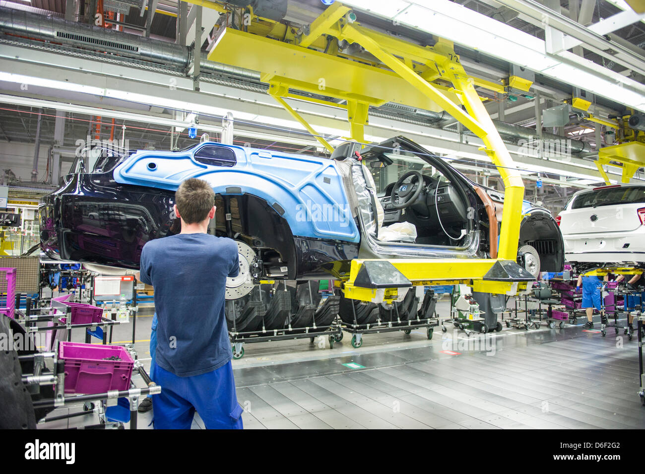 An employee of car manufacturer BMW work on a car at the BMW factory in Regensburg, Germany, 10 April 2013. Photo: Marc Mueller Stock Photo