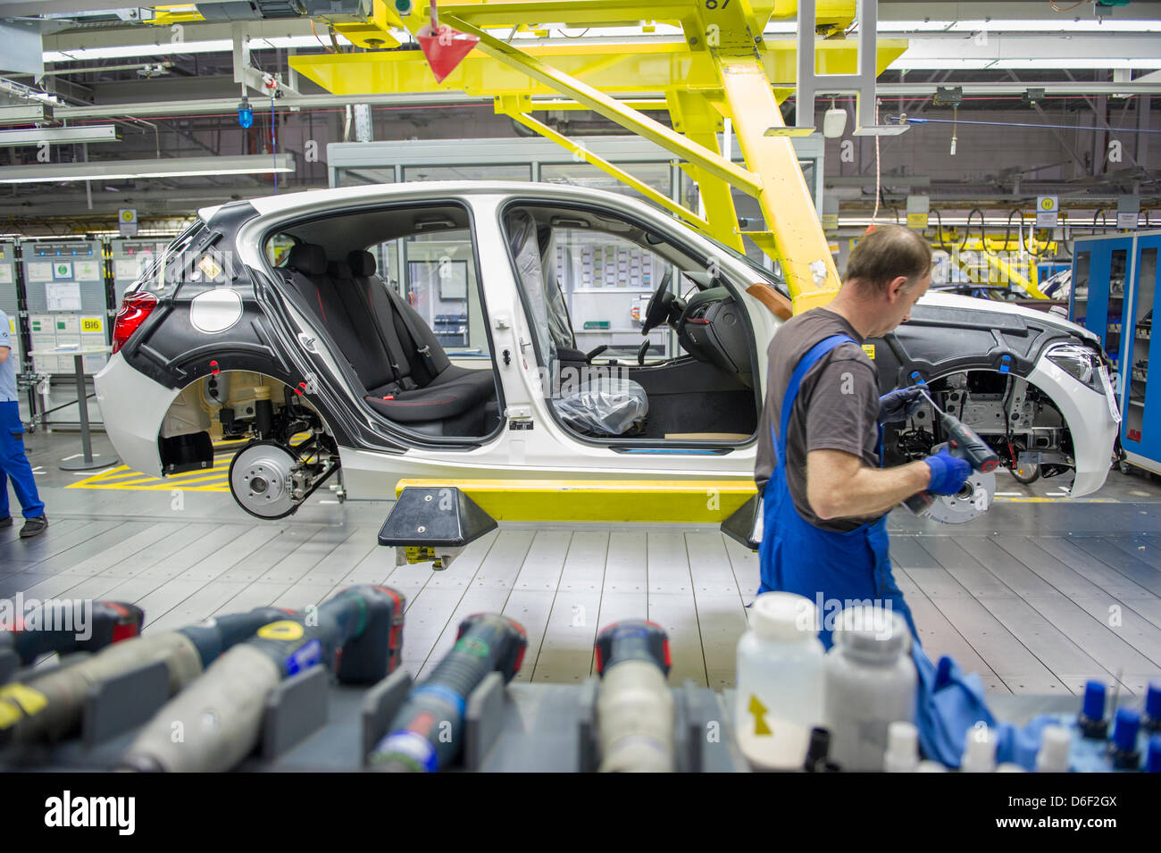 An employee of car manufacturer BMW works on a car at the BMW factory in Regensburg, Germany, 10 April 2013. Photo: Marc Mueller Stock Photo