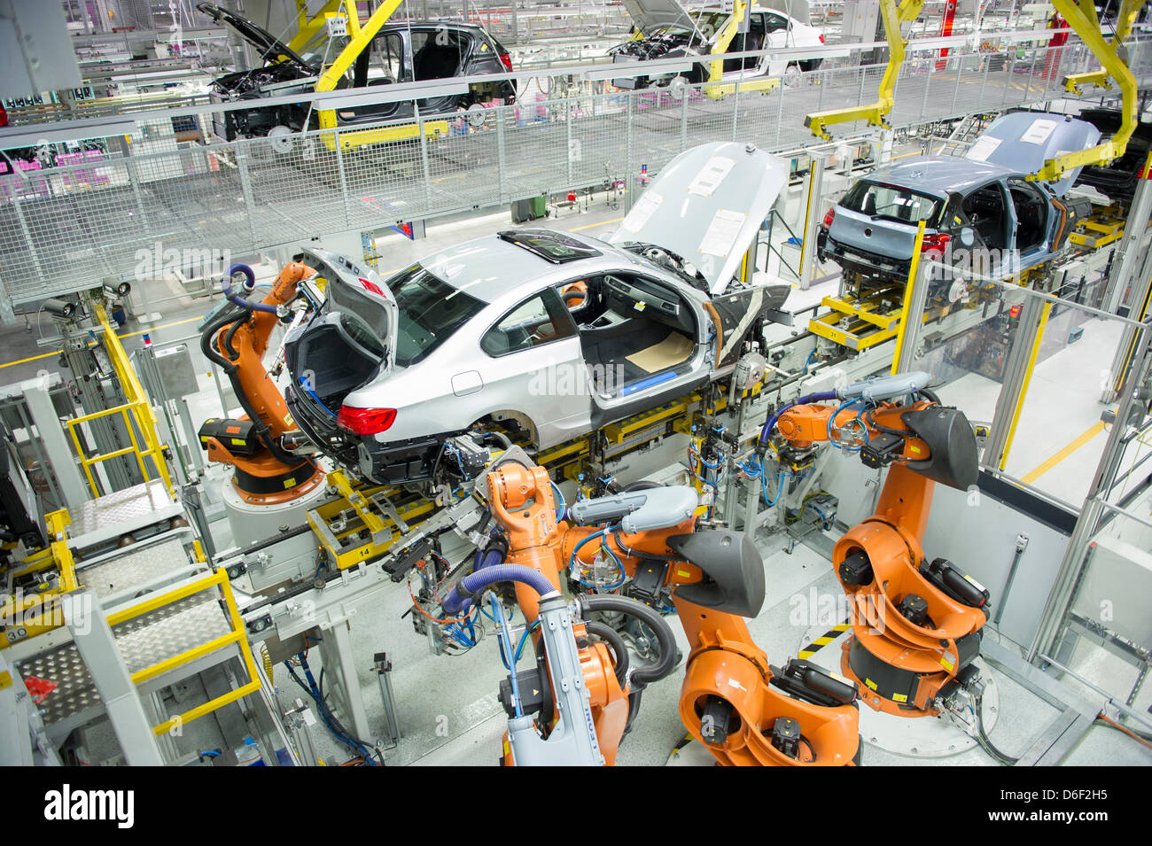 Several robots work on a car at a factory of car manufacturer BMW in Regensburg, Germany, 10 April 2013. Photo: Marc Mueller Stock Photo