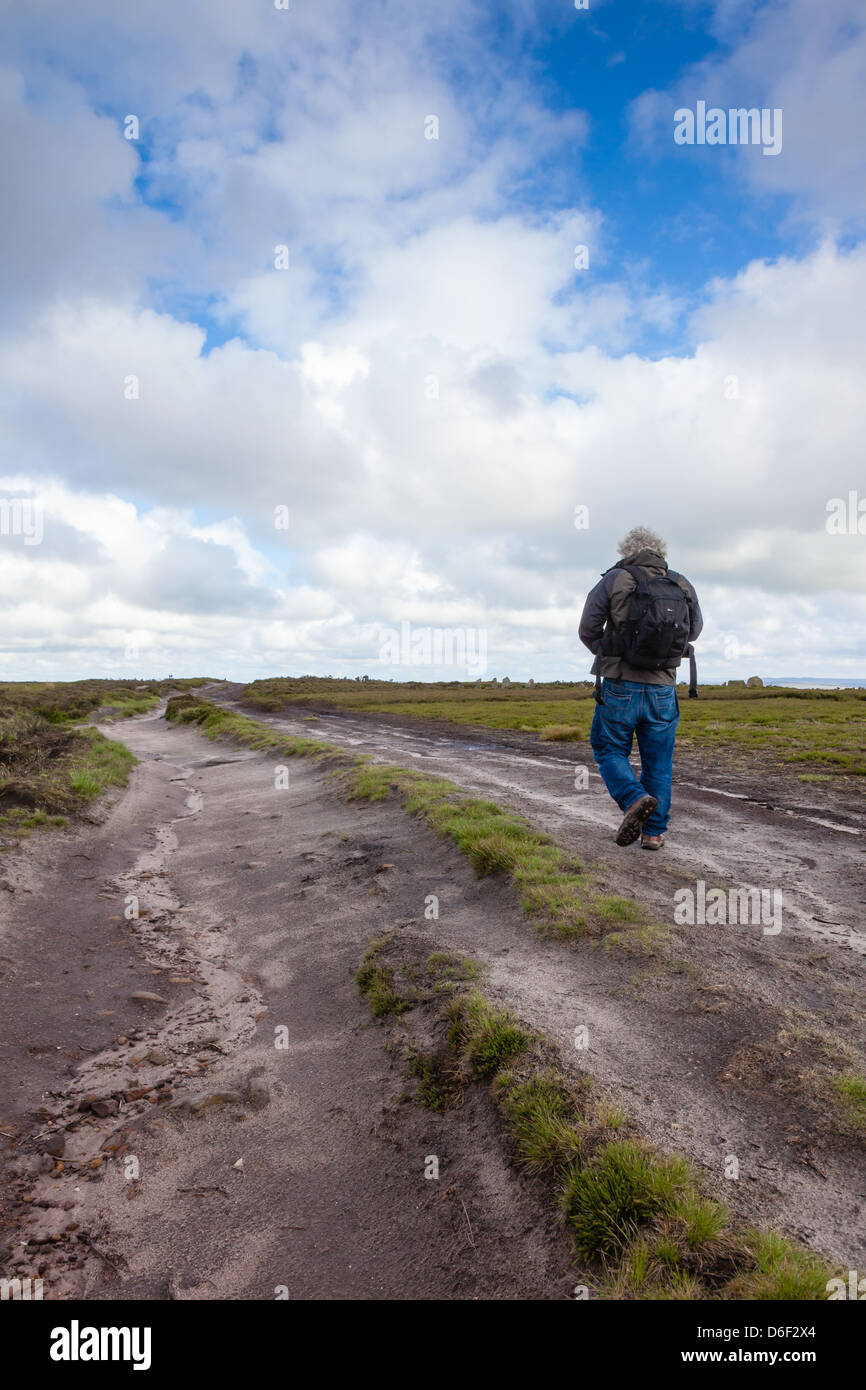 A photographer walks along the Dales Way on Ilkley Moor, Ilkley, West Yorkshire, UK Stock Photo