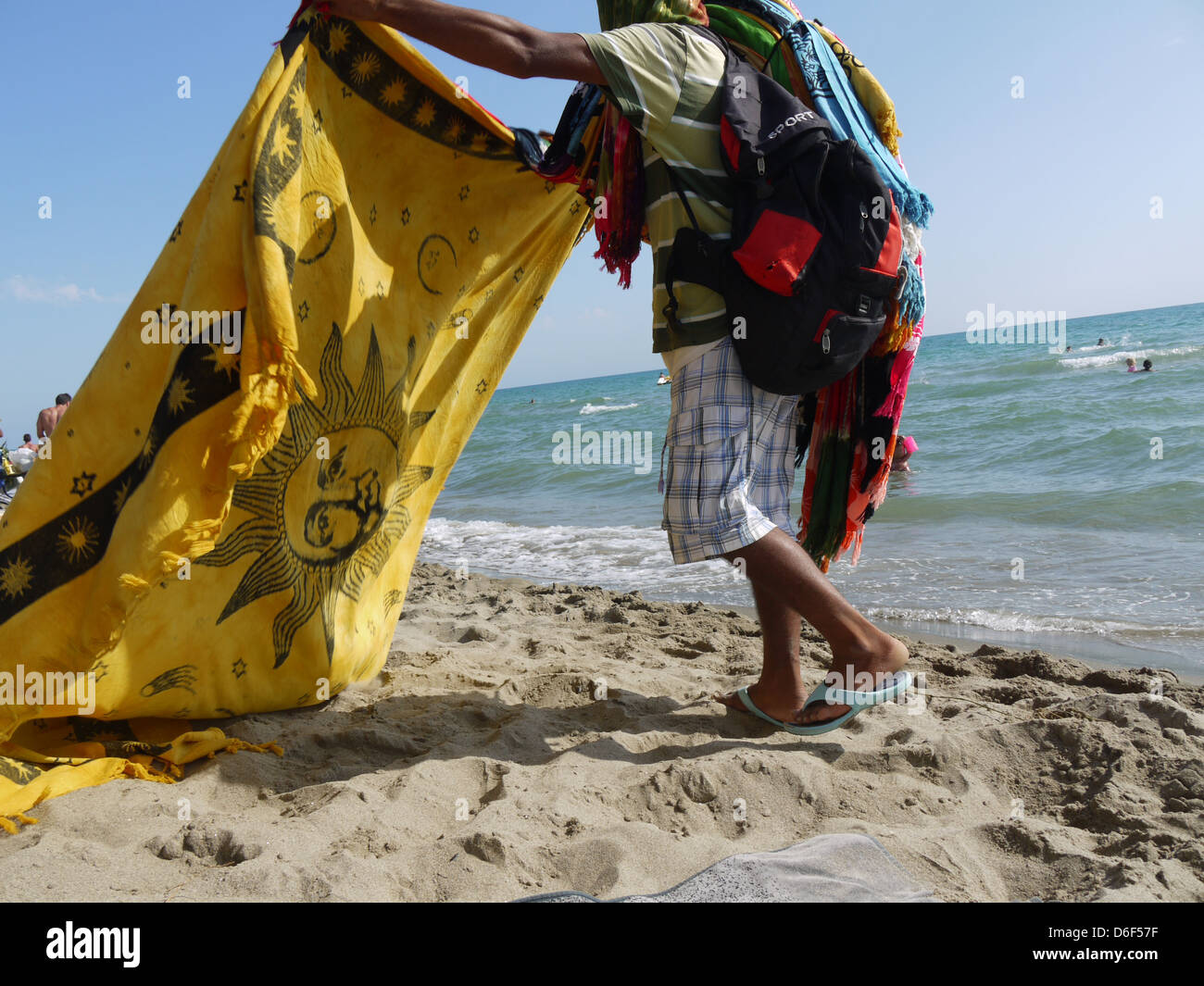 hawker on the beach with yellow scarf Stock Photo