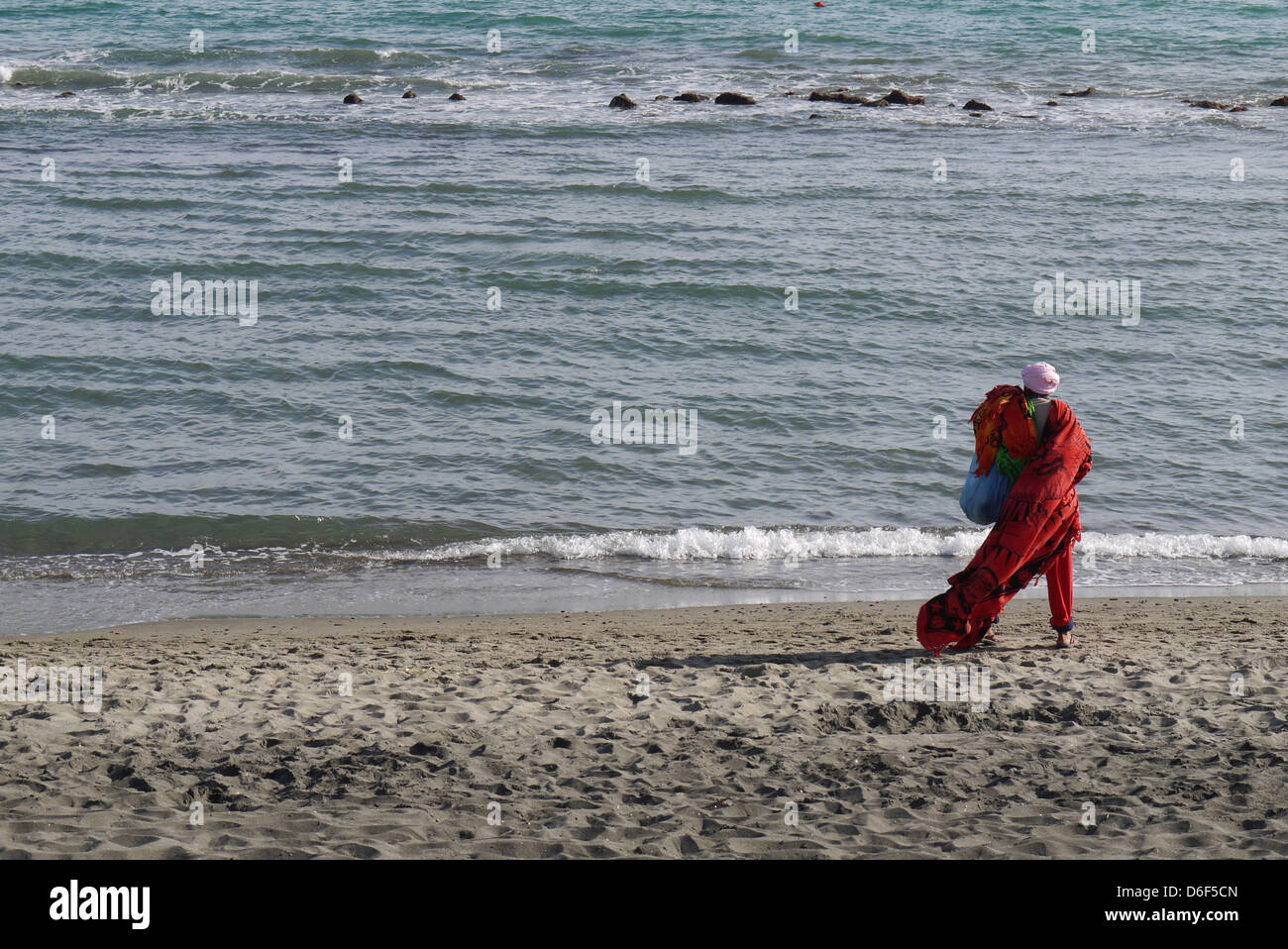 hawker on the beach dressed in red Stock Photo