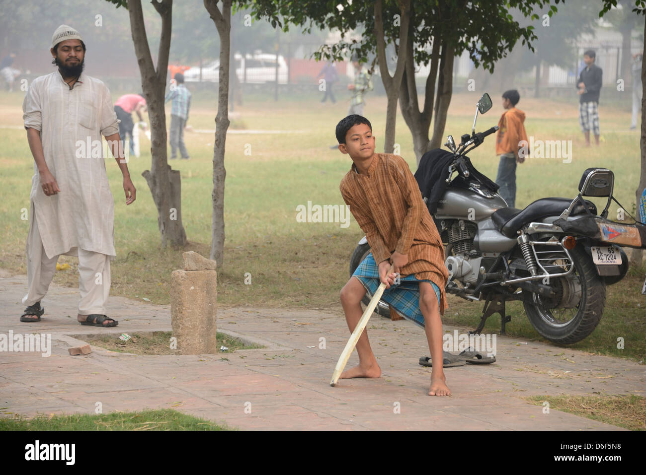 Indian boys playing cricket in a park in Delhi, India Stock Photo