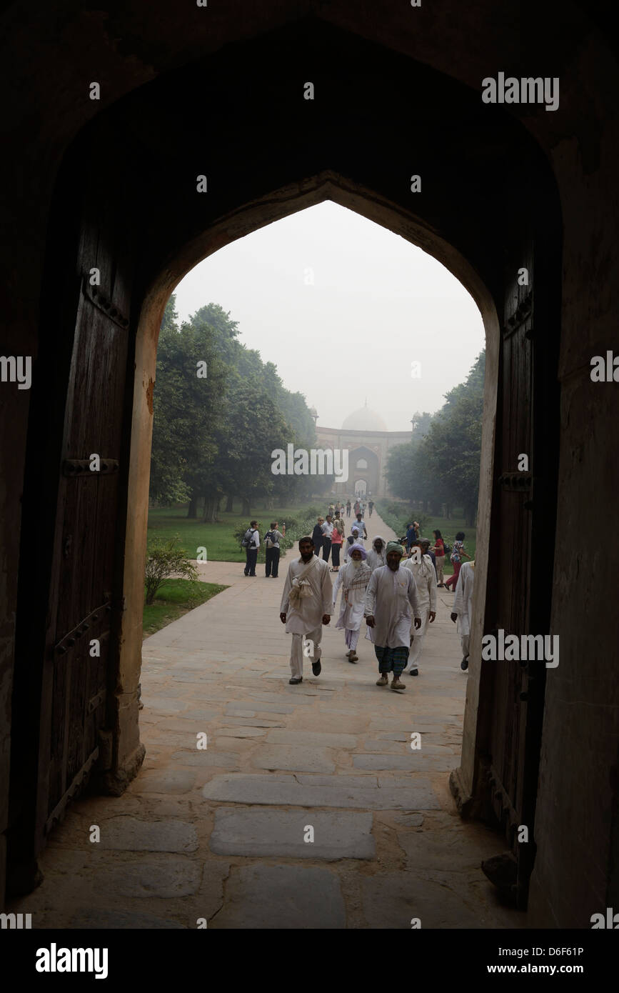 Visitors walk from the arch of West Gate towards the Humayun's tomb where the 2nd Mughal emperor is buried in Delhi, India. Stock Photo