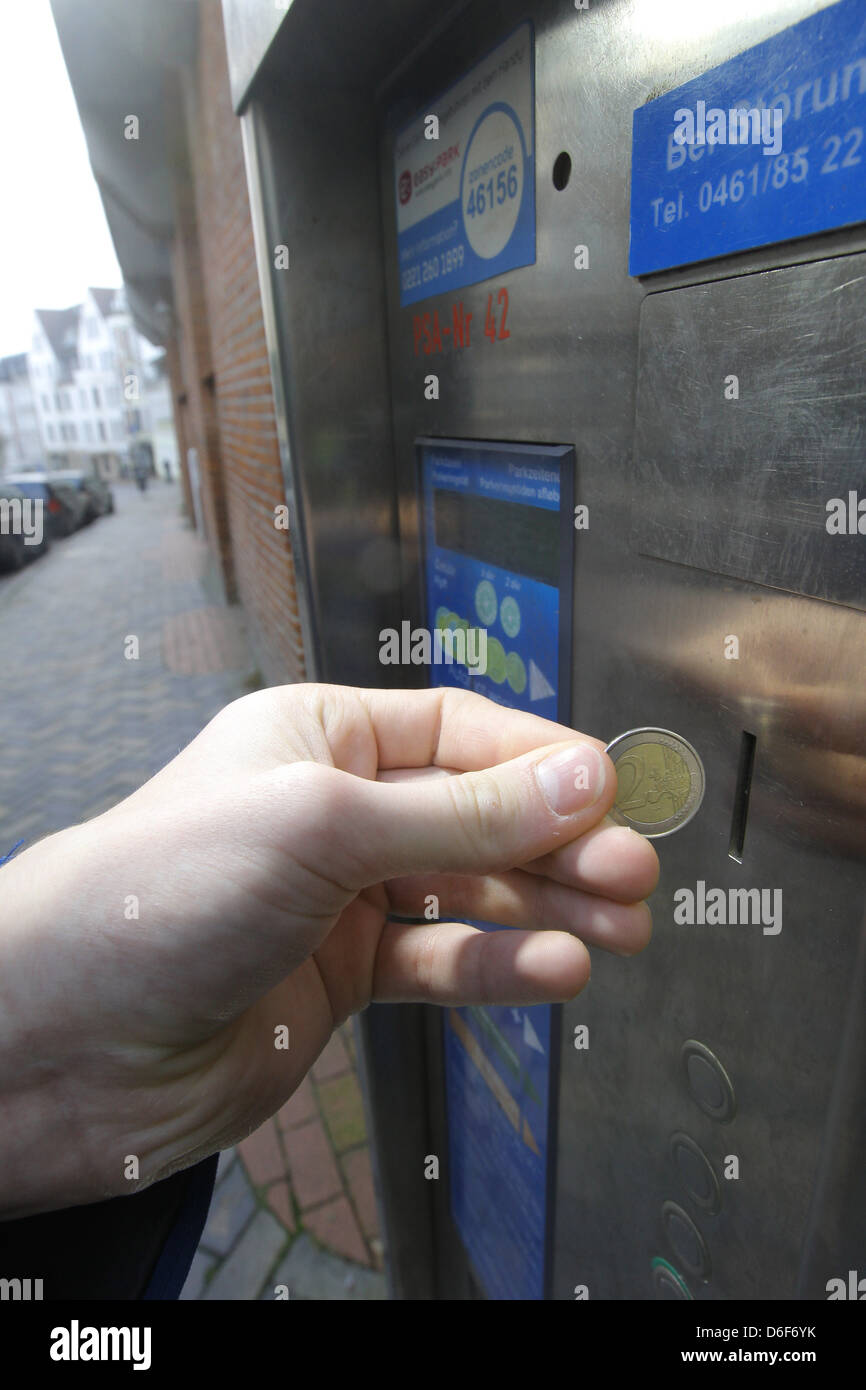 Handewitt, Germany, a motorist lies a 2-euro coin in a parking meter Stock Photo