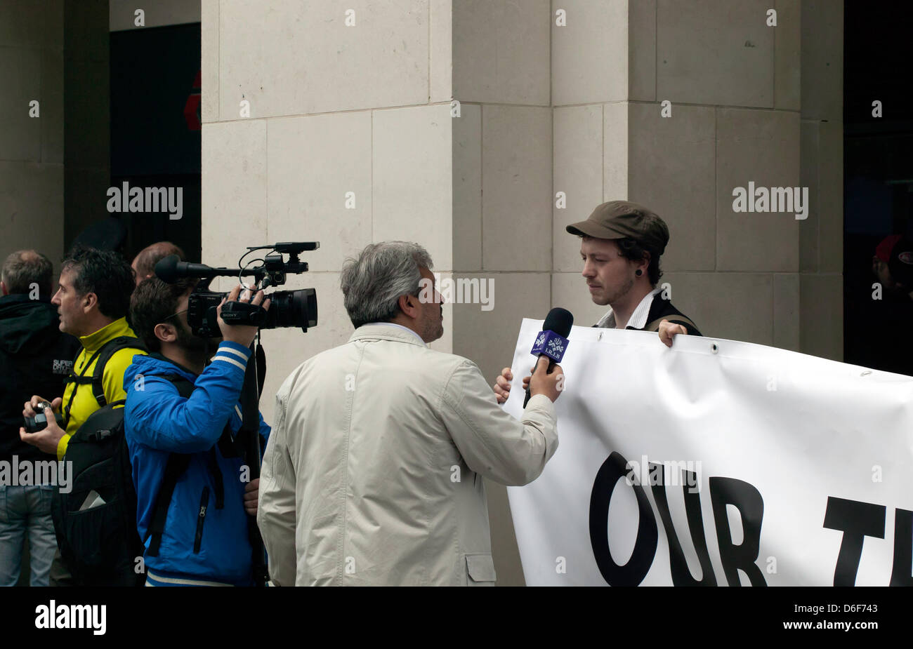Anti-Thatcher protestor being interviewed outside St Paul's Cathedral, by a crew from Islamic Republic of Iran Broadcasting after Baroness Thatcher’s funeral. Stock Photo