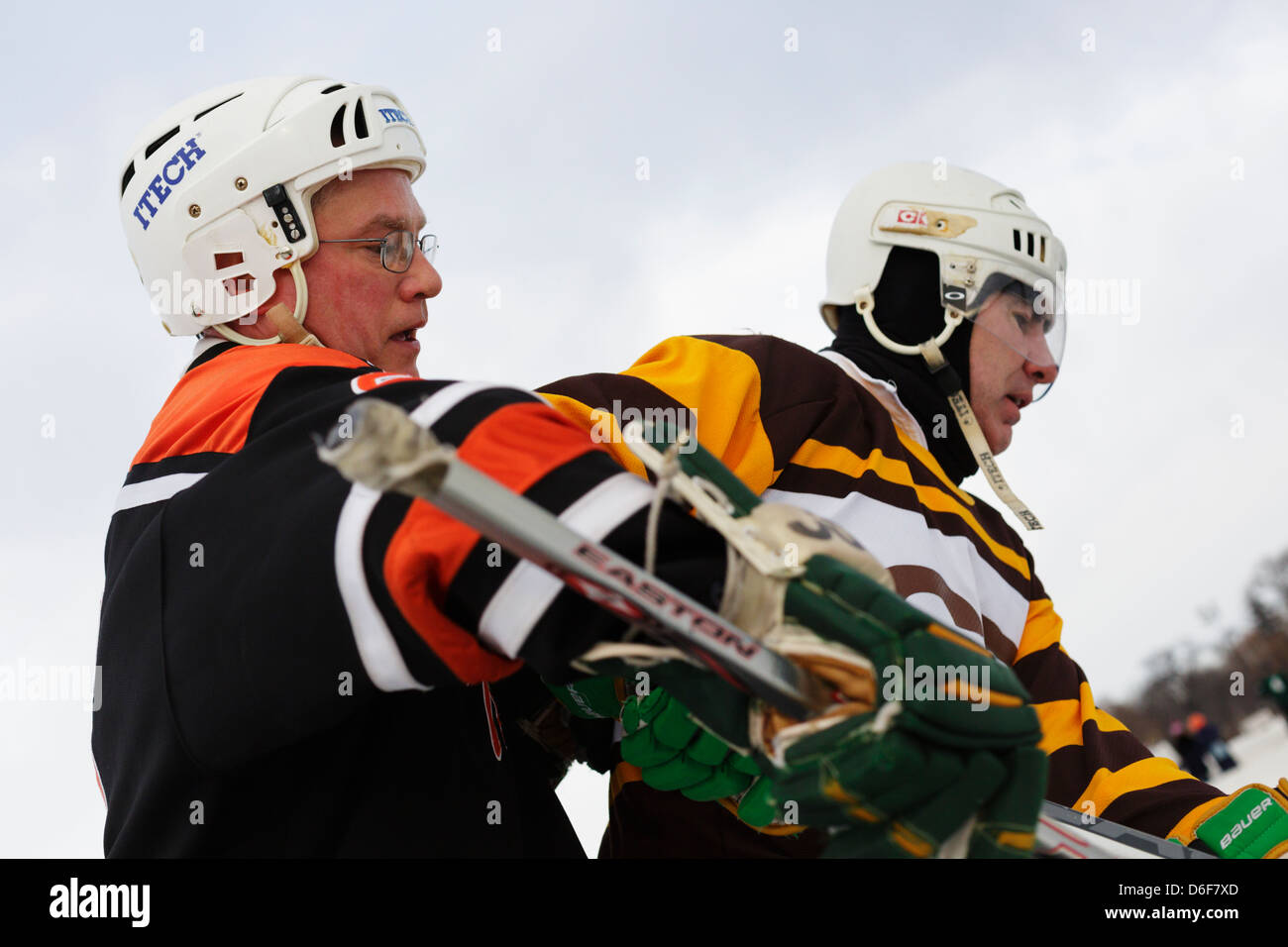 Two men battle during a game at the U.S. Pond Hockey Championships on Lake Nokomis on January 19, 2013 in Minneapolis, Minnesota Stock Photo