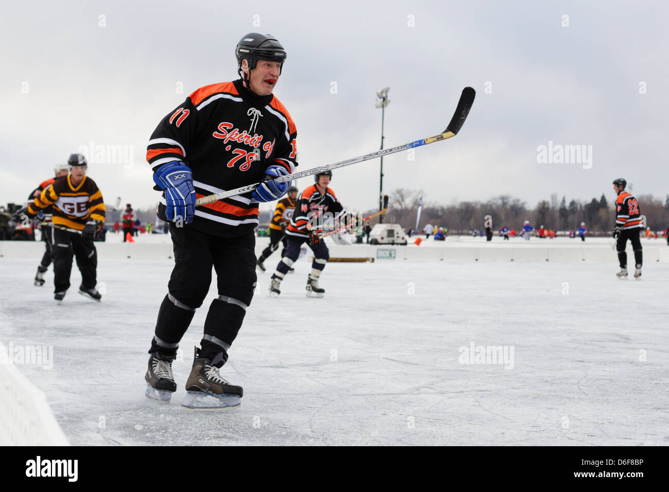 A middle aged player competes at the U.S. Pond Hockey Championships on Lake Nokomis on January 19 2013 in Minneapolis, Minnesota Stock Photo