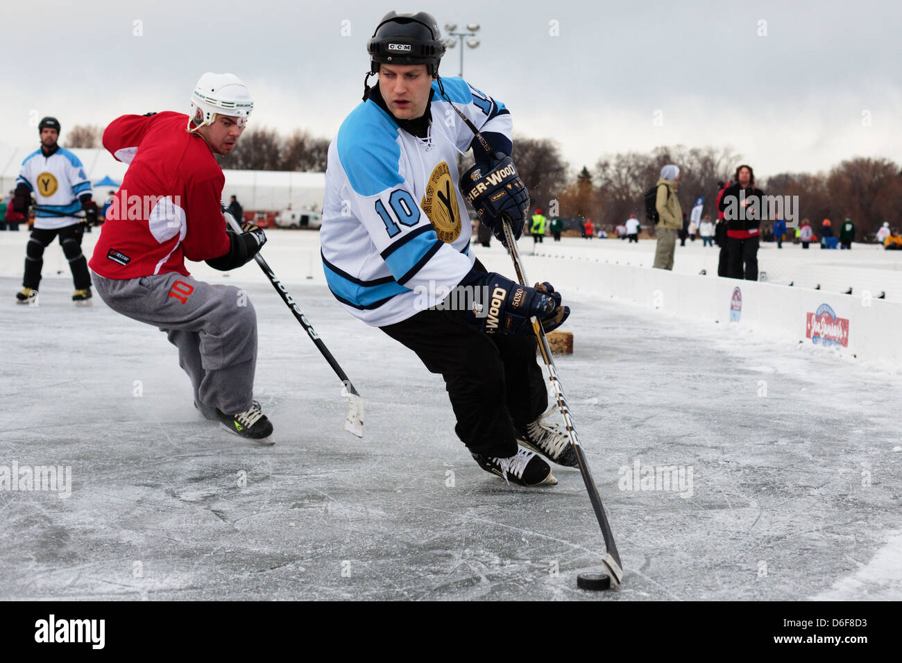 A competitor wheels with the puck during a game at the U.S. Pond Hockey Championships on Lake Nokomis on January 19, 2013. Stock Photo