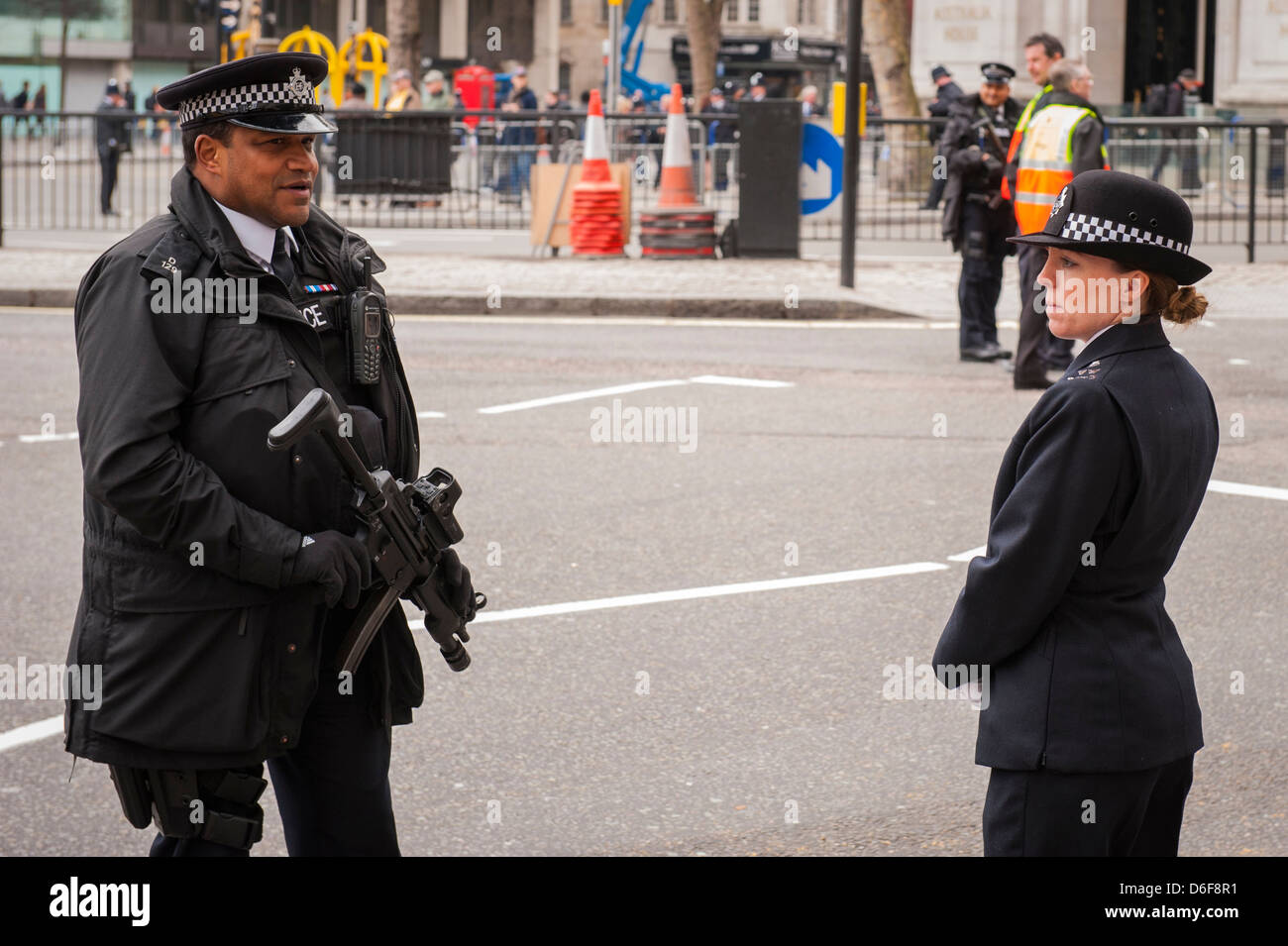 London Strand Baroness Margaret Maggie Thatcher funeral armed policeman with machine gun chats talks to policewoman awaiting parade cortege Stock Photo