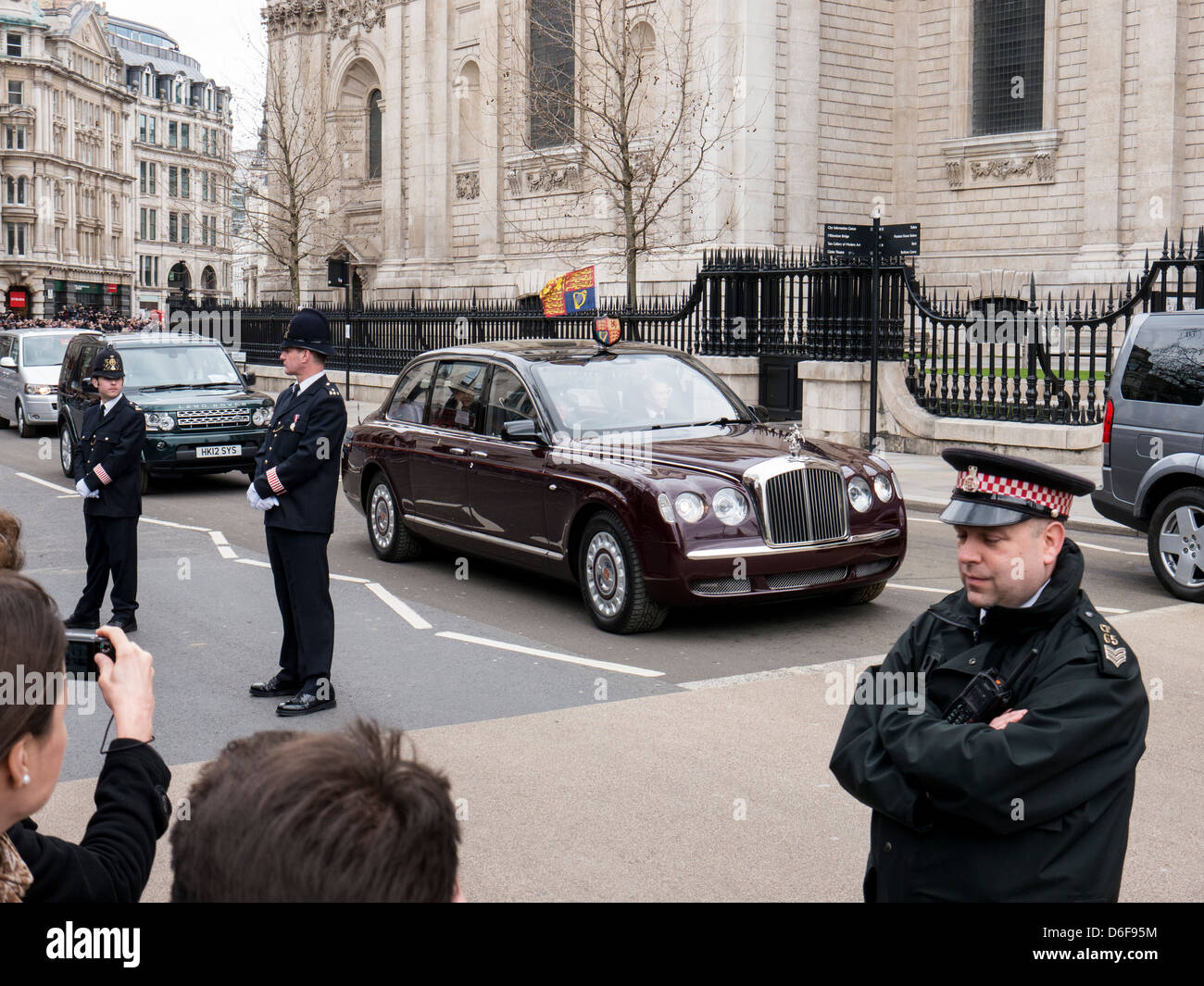 Policeman watching crowd as the Queen leaves in her car at Margaret Thatcher's funeral at St Paul's Cathedral Stock Photo