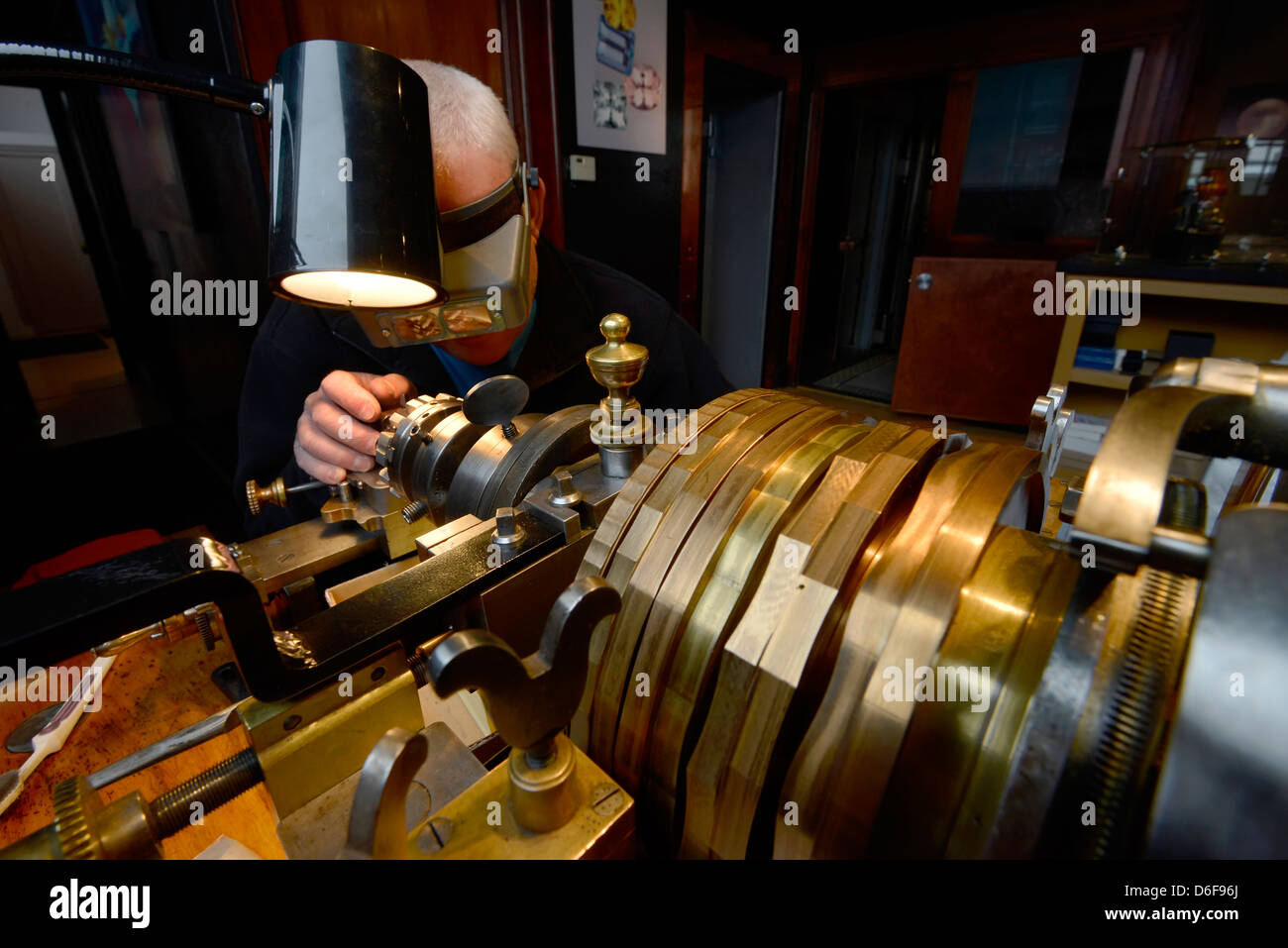 Jeweler engraving a piece of jewelry on an antique rose engine lathe