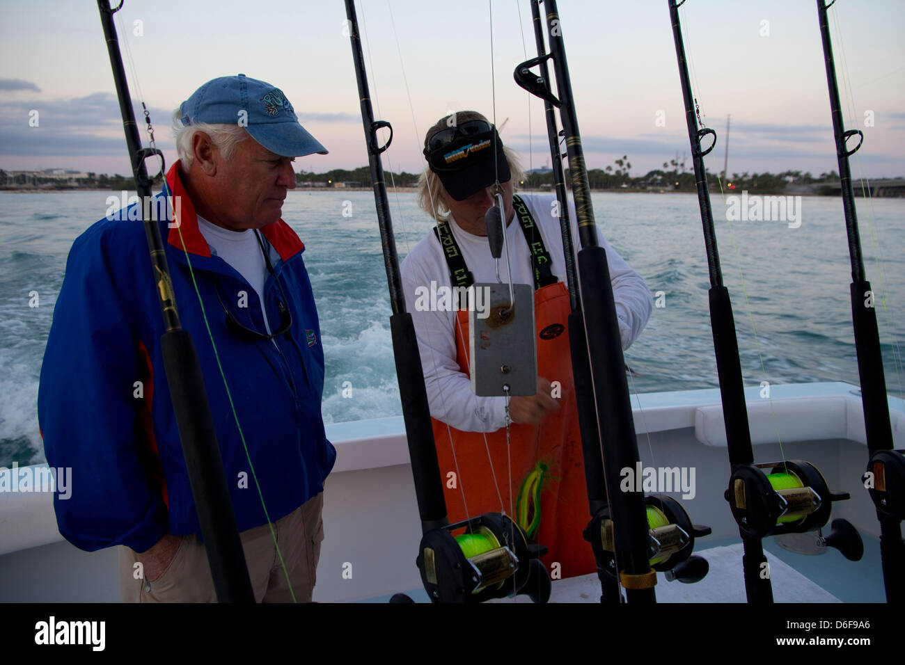Crewman Jason Peer (R) discusses tackle options with fishing