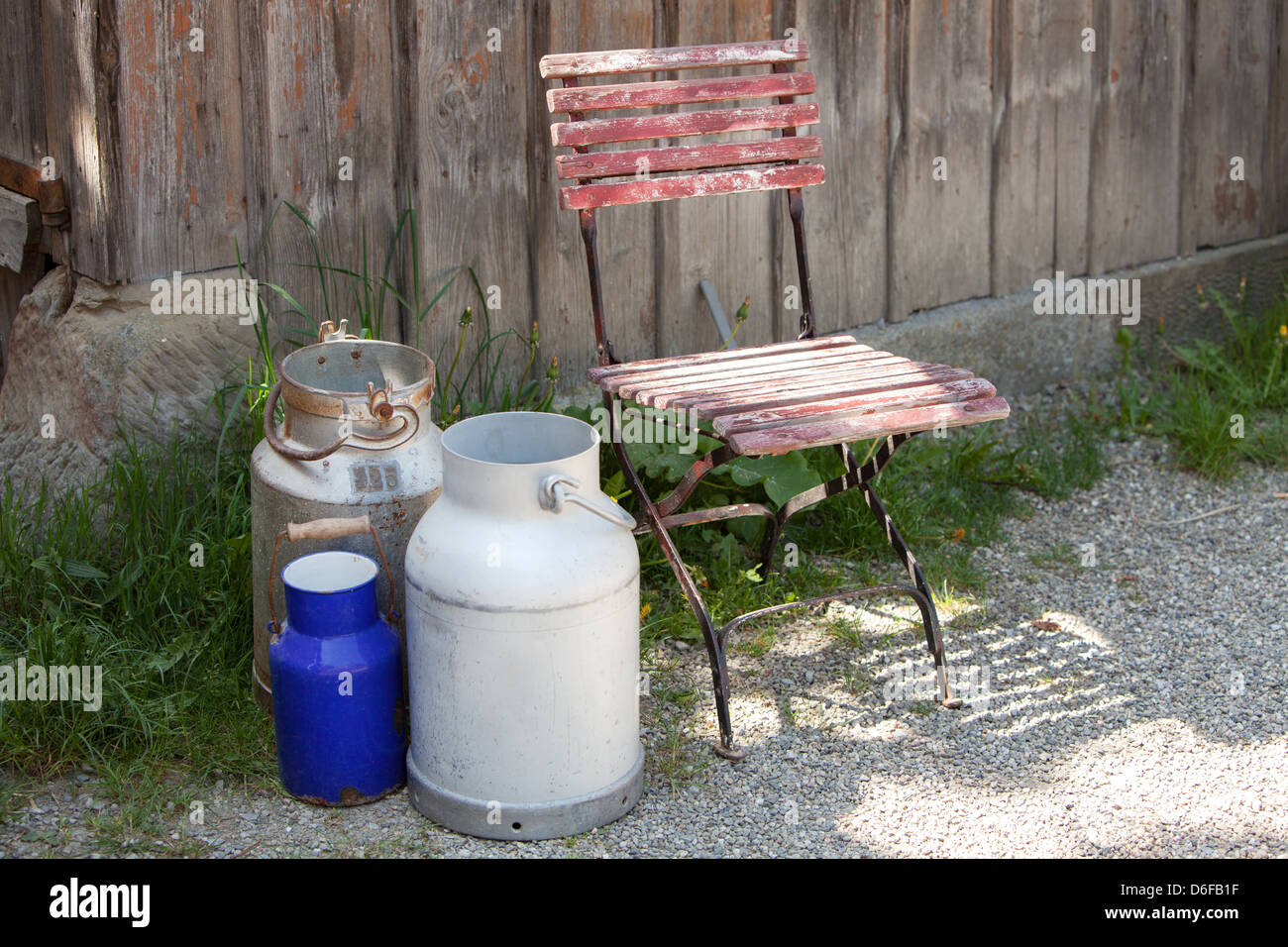 Old milk cans outside a barn Stock Photo
