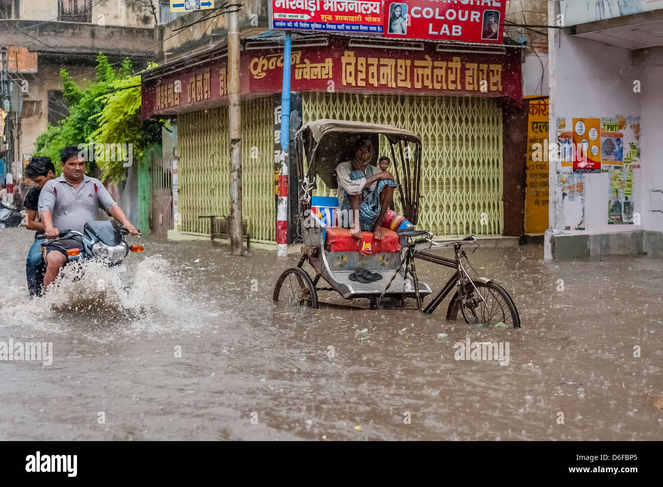 Monsoon rain and flash flood yet people still go about their business in Varanasi, Uttar Pradesh, India. Stock Photo