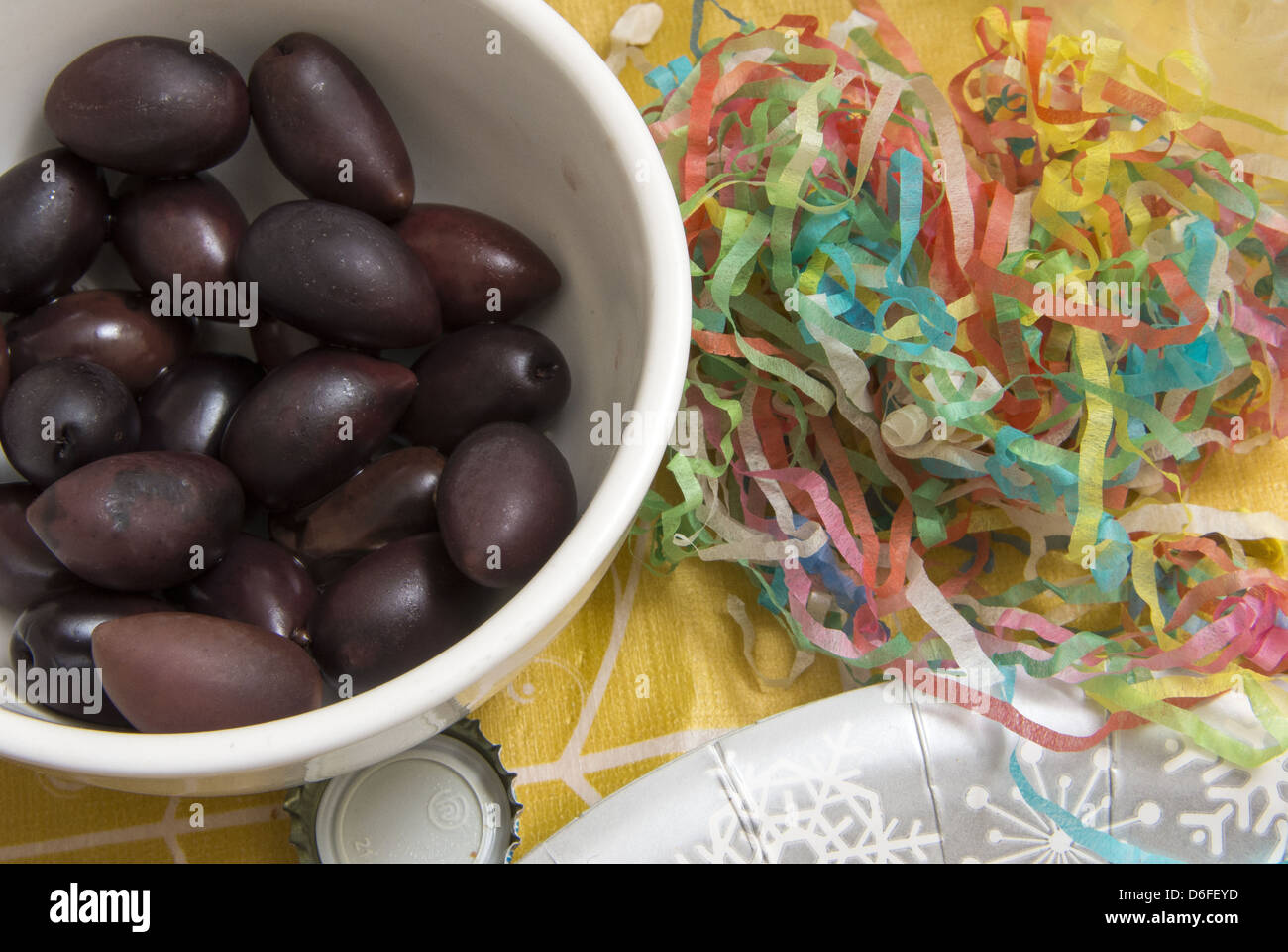 Leftover party food. Olives in a bowl surrounded by party popper