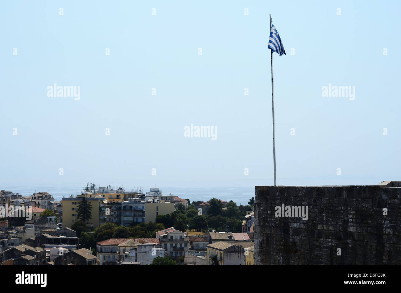 A landscape photograph of a flag and the town in Kavos, Greece. Stock Photo