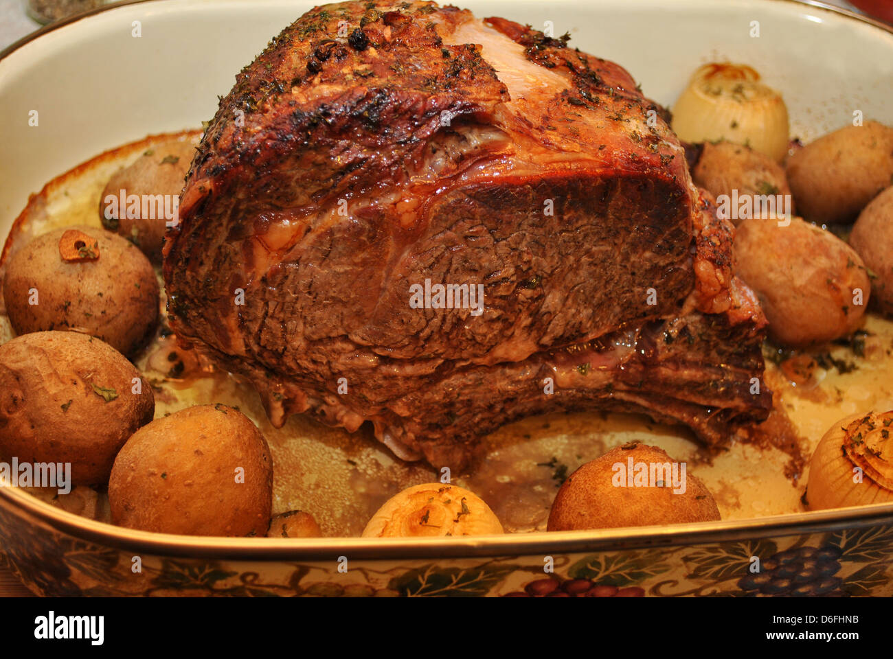 Prime Rib Roast in a Pan with Potatoes and Onions Stock Photo