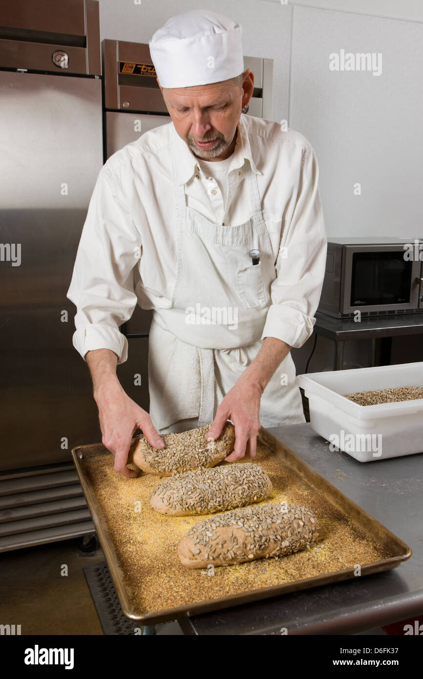 Professional cook preparing fresh bread in a commercial bakery Stock Photo