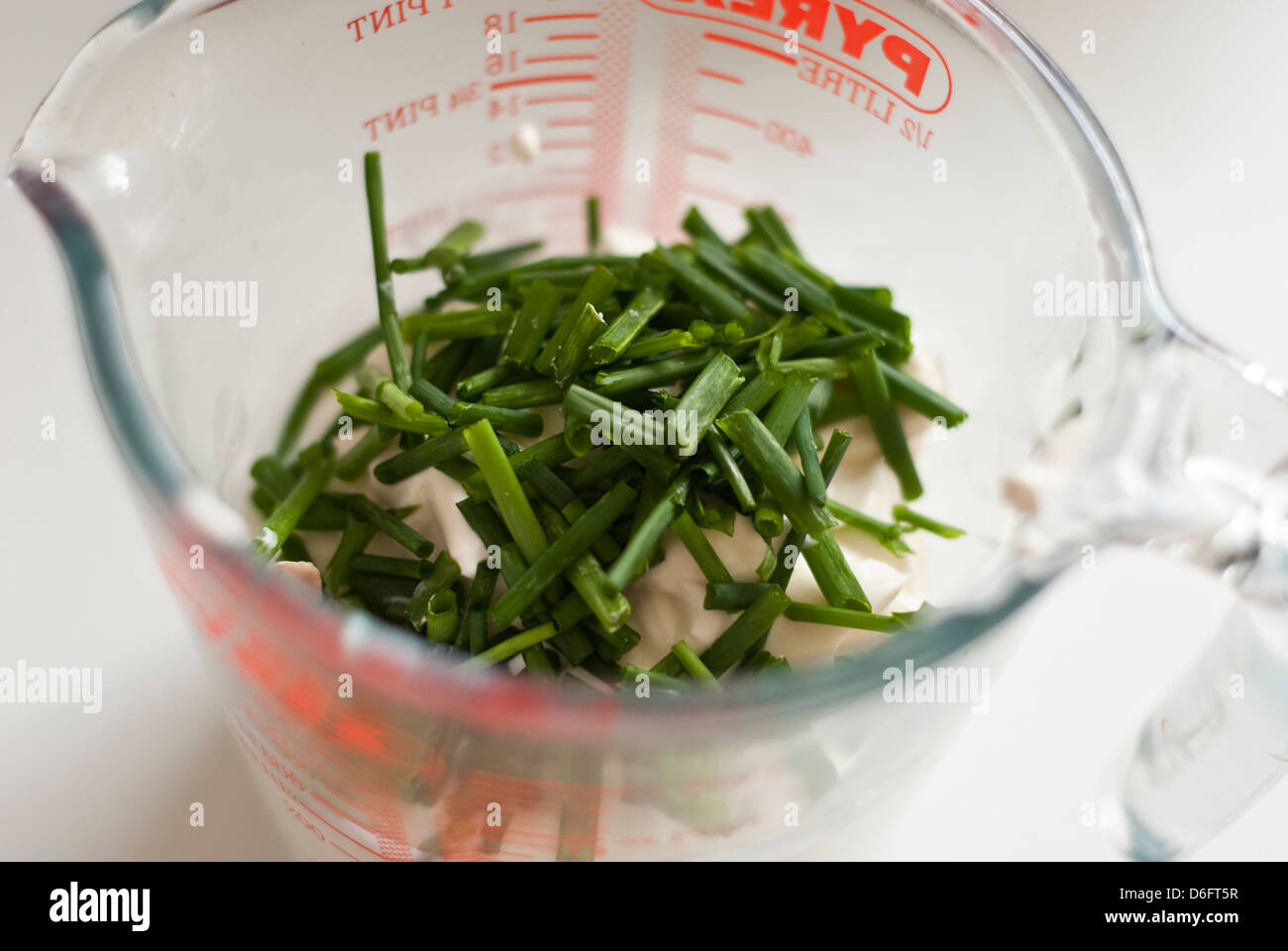 Chives and Creme Fraiche in a Measuring Jug Stock Photo