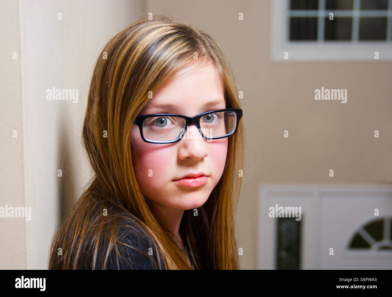 Serious young girl with glasses looking into camera. Stock Photo