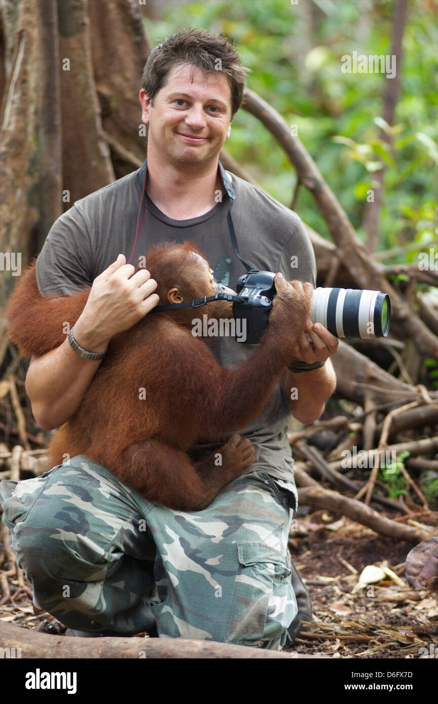 Man with Orangutan and Canon DSLR camera in the Jungle, Nyaru Menteng Orangutan Reintroduction