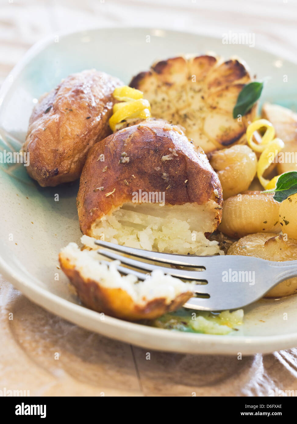 Oven-roasted peeled russets broken into with tines of fork. Stock Photo