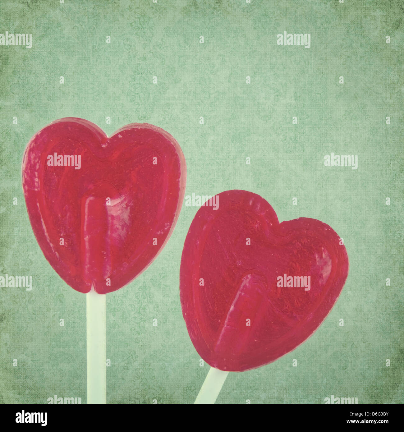 Red lollipop hearts on green vintage background Stock Photo